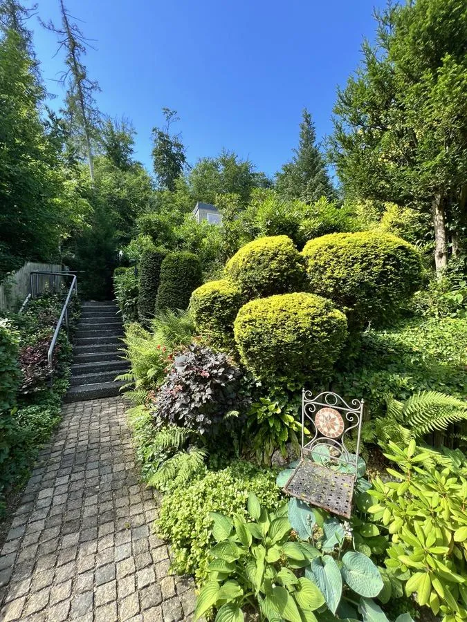 Gepflegter Garten mit Formschnitt-Gehölzen und Natursteinweg – Gartenpflege Goslar